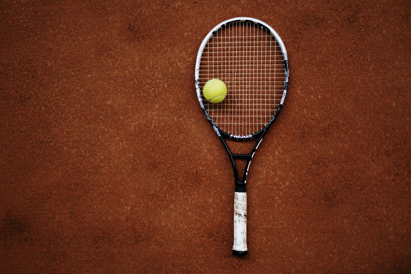 Tennis racket and ball on a clay court